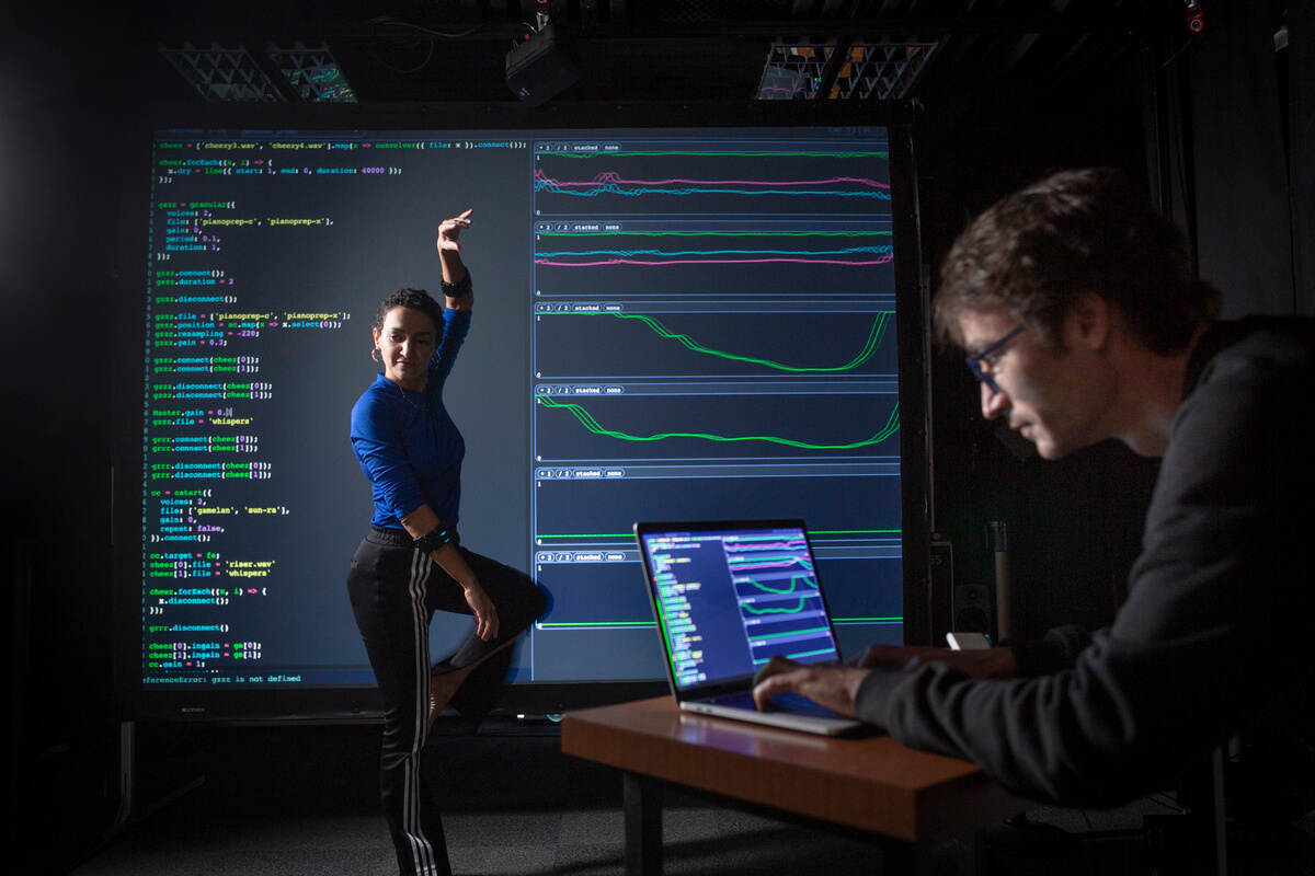 Une femme effectue des mouvements de danse pendant un chercheur analyse le mouvement sur son ordinateur 